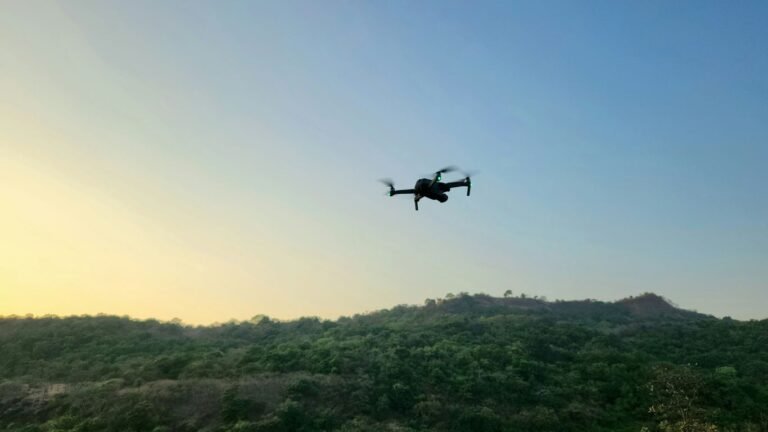 a small plane flying over a lush green hillside